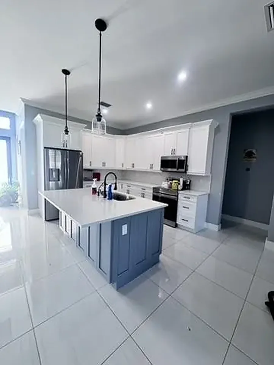 Finished kitchen with white cabinets and a blue island